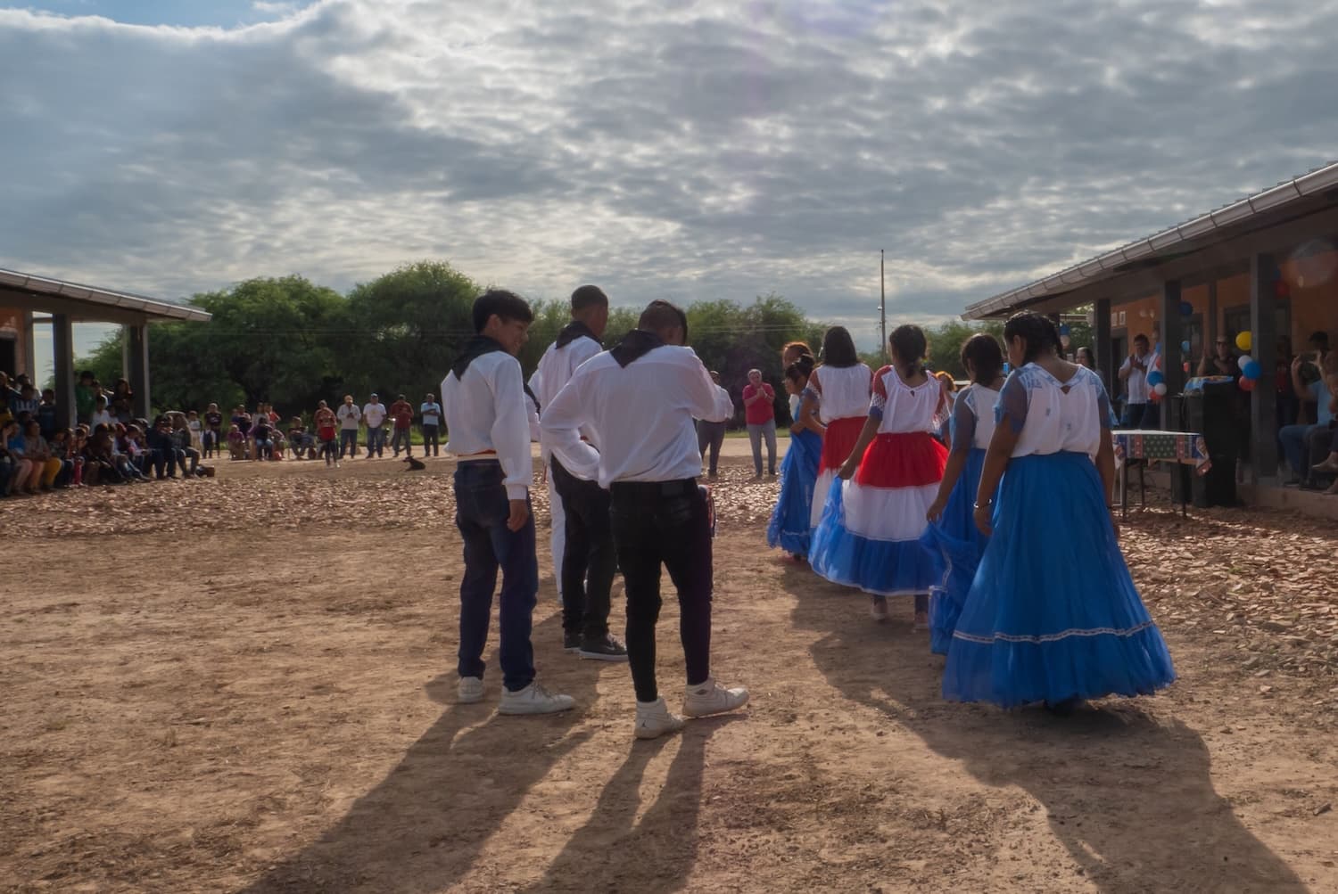 Several youth dressed in traditional clothing preparing for a dance