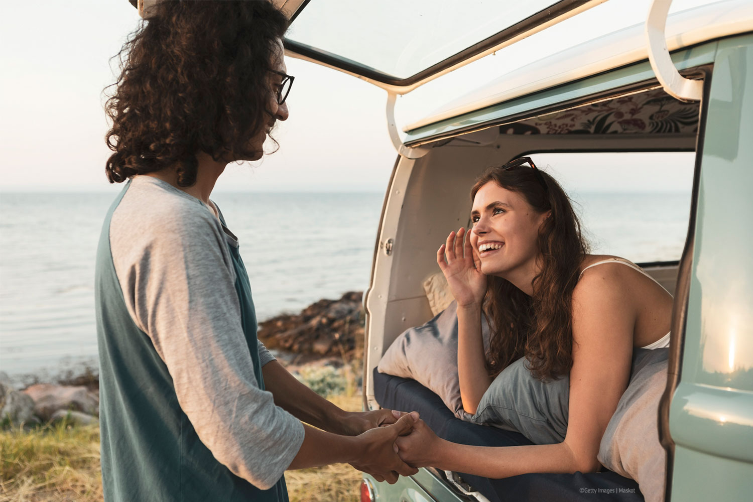 Smiling woman talking with male friend at seashore